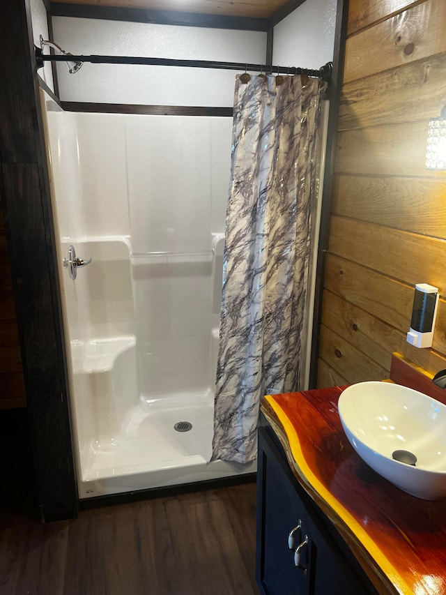 bathroom featuring wood walls, curtained shower, hardwood / wood-style flooring, and vanity