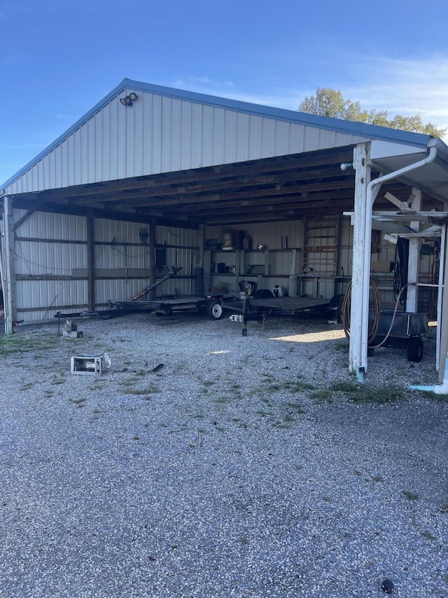 view of parking featuring an outbuilding, a carport, and driveway