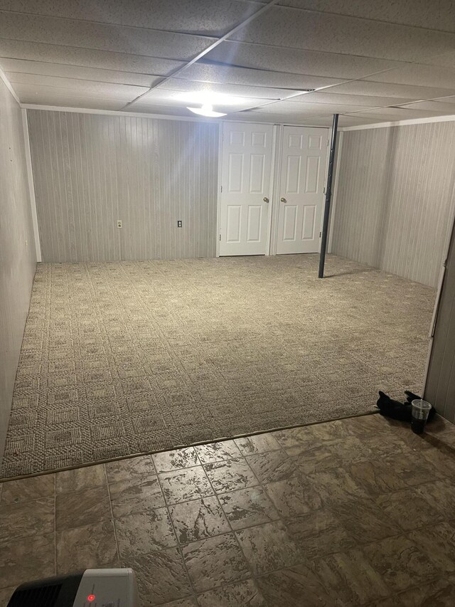 carpeted empty room with a paneled ceiling