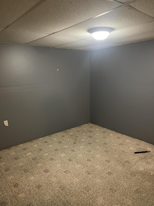 unfurnished room with a paneled ceiling and carpet