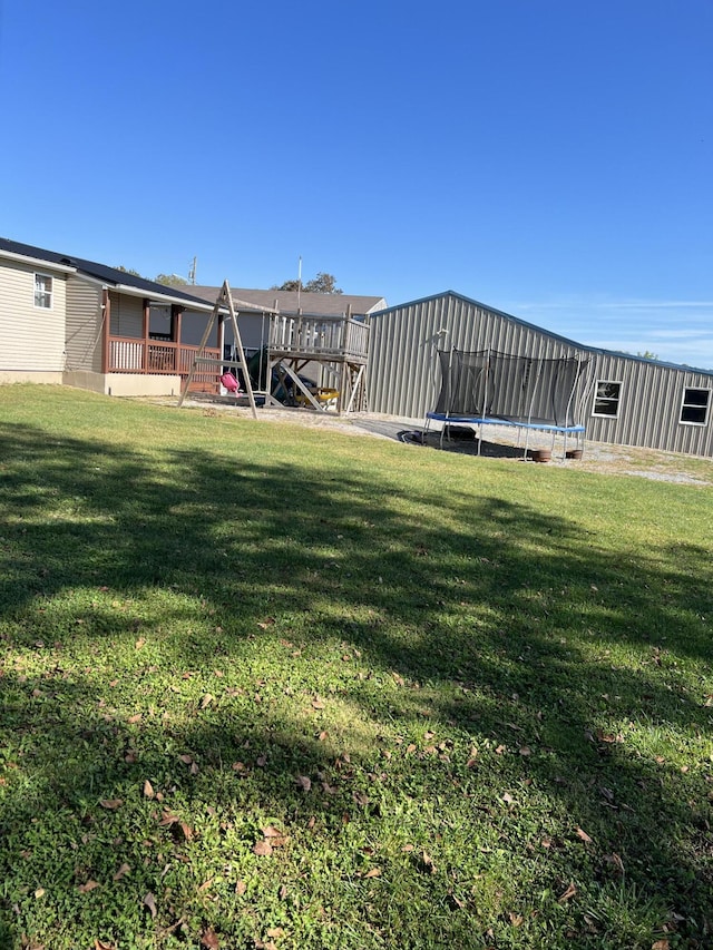 view of yard featuring a trampoline and a playground