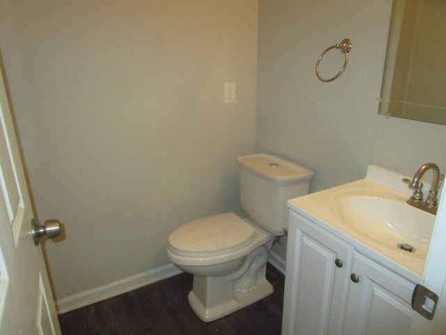 bathroom featuring hardwood / wood-style flooring, toilet, and vanity