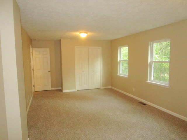 carpeted spare room featuring a textured ceiling