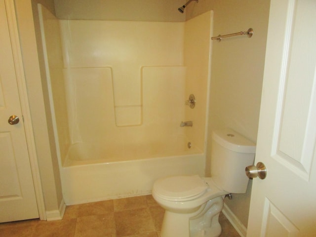 bathroom featuring tile patterned flooring, tub / shower combination, and toilet