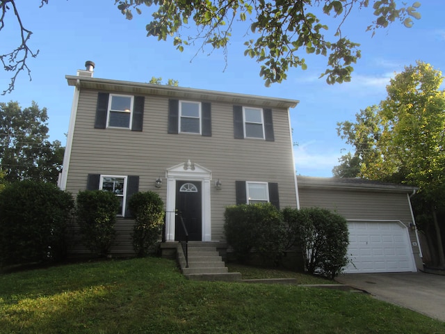 colonial house featuring a front yard and a garage