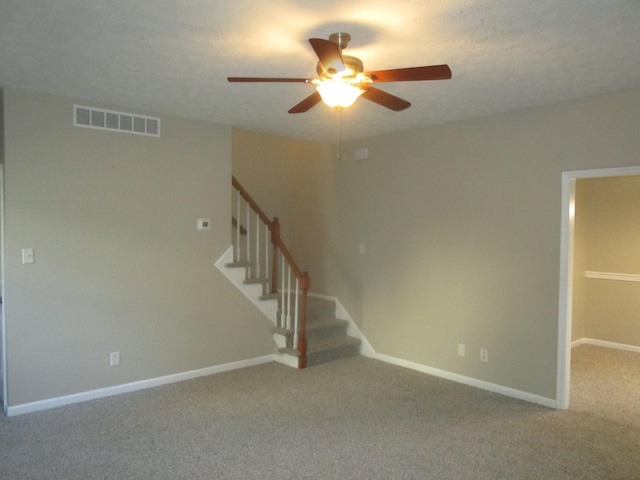 carpeted spare room with ceiling fan and a textured ceiling