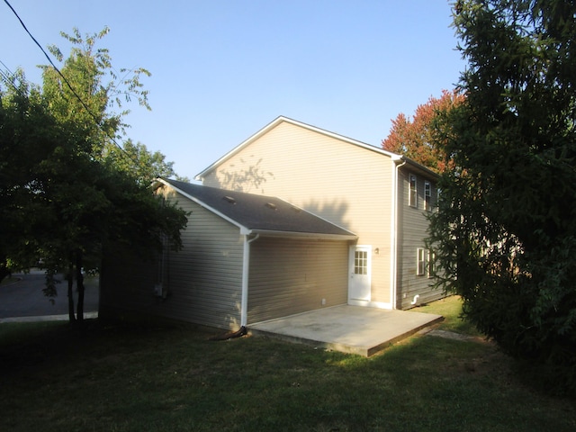 back of property with a yard and a patio area