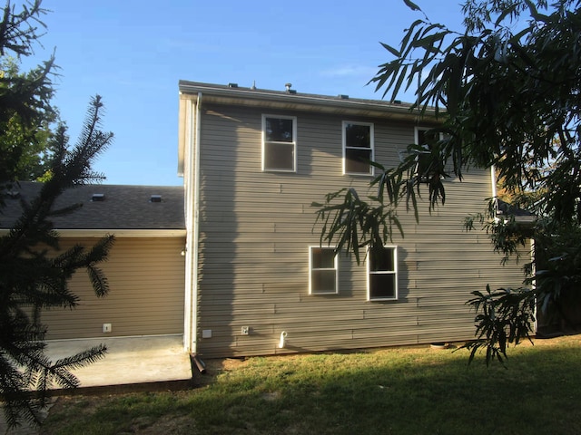 rear view of property featuring a yard and a patio area