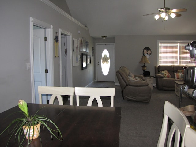 carpeted dining room featuring ceiling fan, lofted ceiling, and ornamental molding