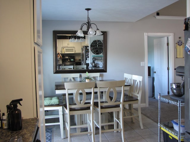 tiled dining space featuring crown molding and a chandelier