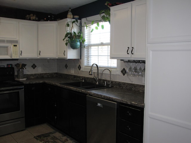 kitchen featuring white cabinets, appliances with stainless steel finishes, sink, and tasteful backsplash