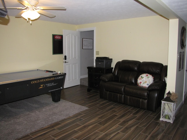 living room with ceiling fan and dark wood-type flooring