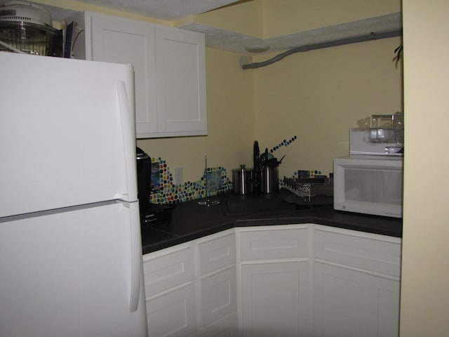 kitchen with white appliances and white cabinets