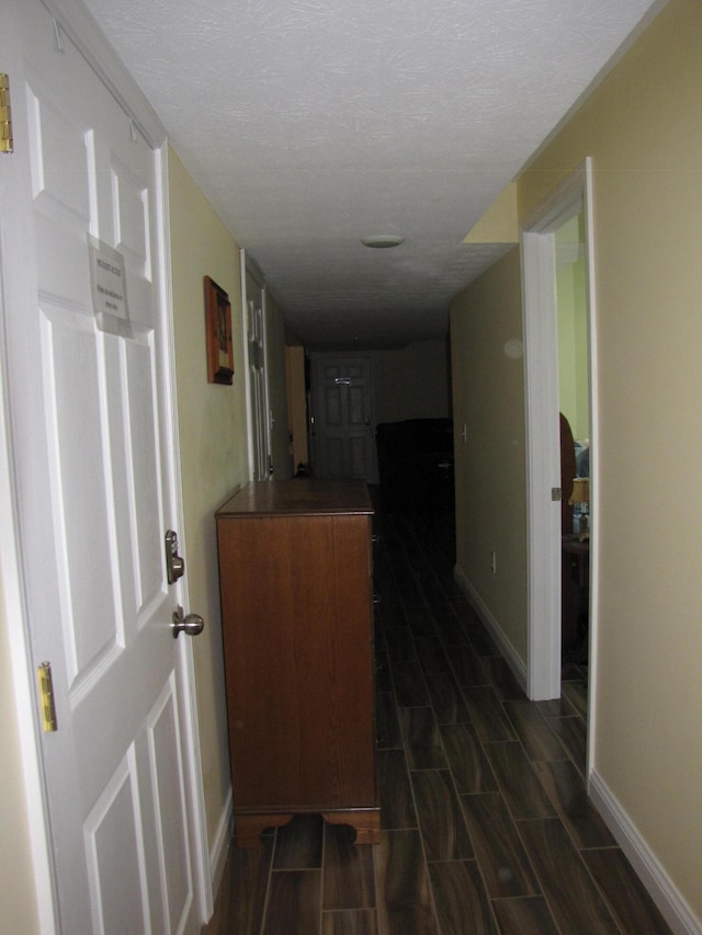 hall featuring dark hardwood / wood-style floors and a textured ceiling