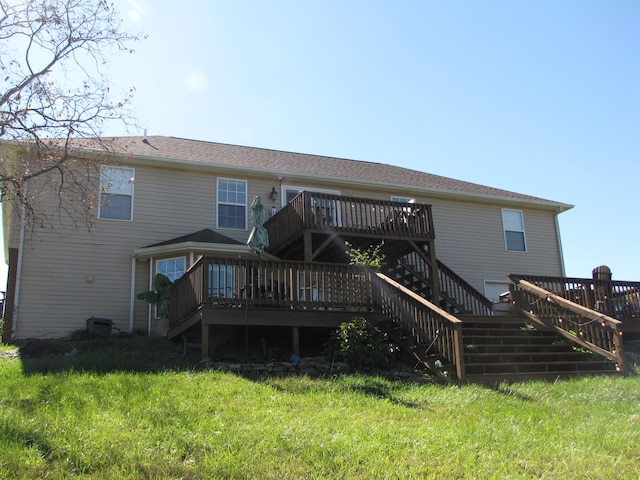 back of property with a yard and a wooden deck