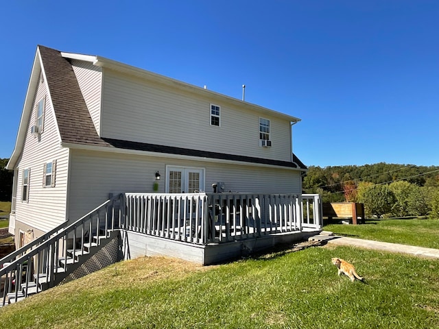 rear view of property with a wooden deck and a lawn