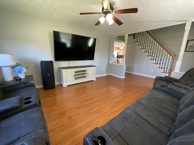 living room with ceiling fan, a textured ceiling, and hardwood / wood-style floors