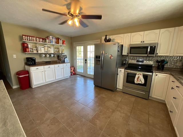 kitchen with ceiling fan, backsplash, french doors, appliances with stainless steel finishes, and white cabinetry