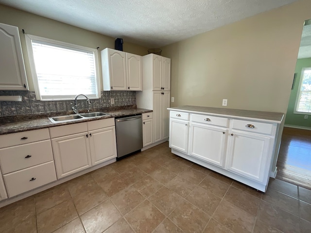 kitchen featuring plenty of natural light, white cabinets, sink, and stainless steel dishwasher