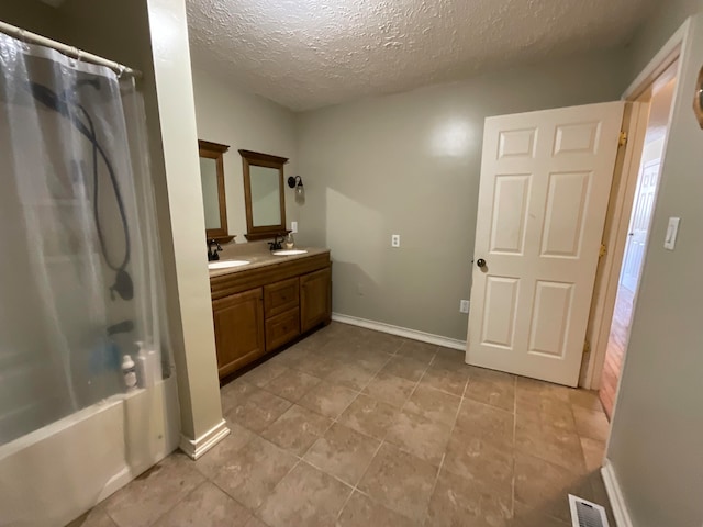 bathroom with shower / tub combo with curtain, vanity, and a textured ceiling