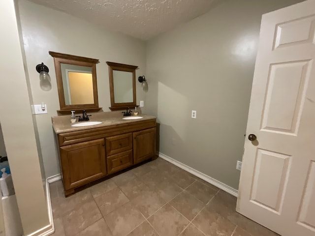 bathroom featuring tile patterned floors, vanity, and a textured ceiling