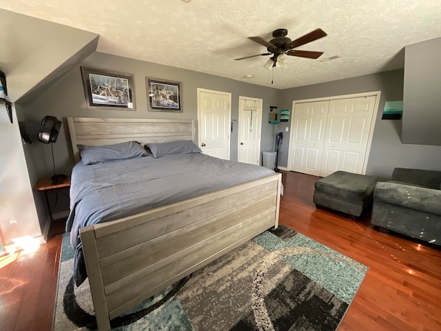 bedroom featuring a textured ceiling, ceiling fan, and dark hardwood / wood-style flooring