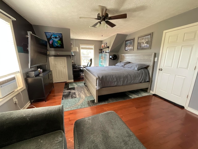 bedroom featuring ceiling fan, vaulted ceiling, a textured ceiling, and dark wood-type flooring