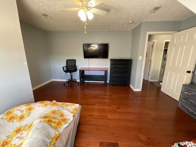 bedroom featuring ceiling fan, dark hardwood / wood-style flooring, and a textured ceiling