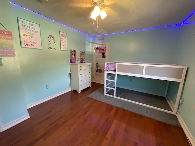 unfurnished bedroom with dark hardwood / wood-style flooring, a textured ceiling, and ceiling fan