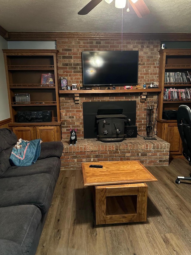 living room featuring crown molding, wood-type flooring, a textured ceiling, and ceiling fan