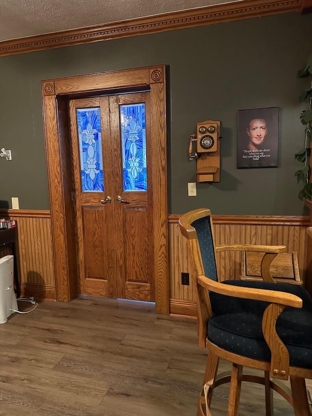 entryway featuring wood walls, wood-type flooring, and a textured ceiling