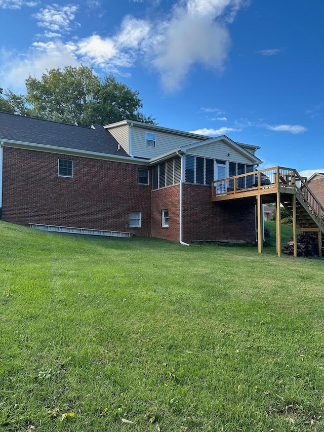 rear view of property with a lawn and a deck