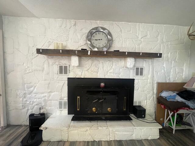 room details with wood-type flooring and a stone fireplace