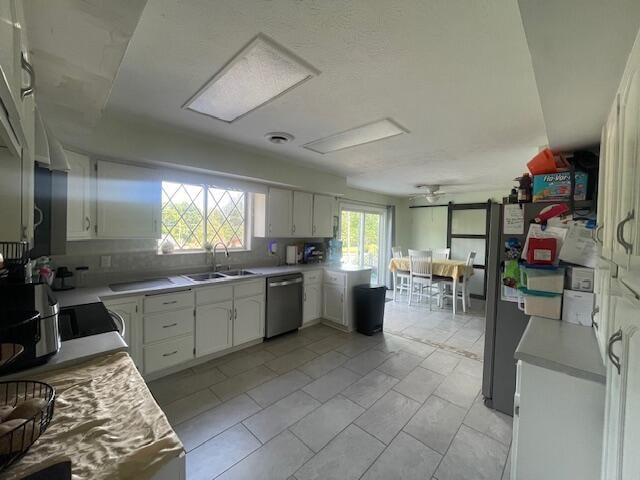 kitchen featuring white cabinets, light tile patterned flooring, sink, tasteful backsplash, and stainless steel appliances