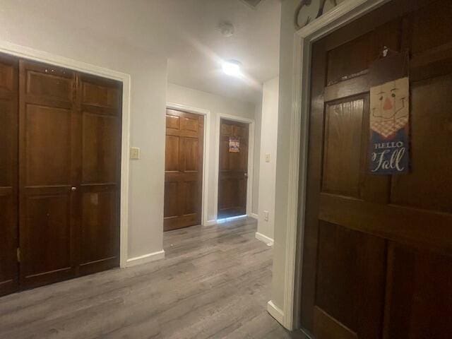 hallway with light hardwood / wood-style floors