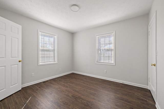 unfurnished bedroom featuring a textured ceiling and dark wood-type flooring