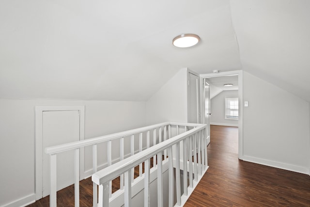 hall with dark hardwood / wood-style floors and vaulted ceiling