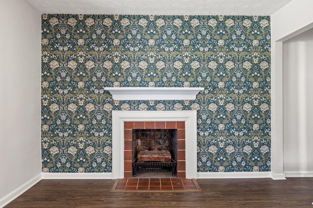 room details with wood-type flooring, a textured ceiling, and a tile fireplace