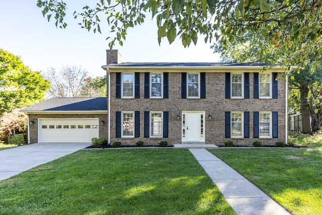 colonial-style house with driveway, a chimney, brick siding, a front lawn, and an attached garage