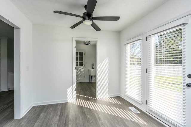 empty room featuring ceiling fan, dark hardwood / wood-style floors, and a textured ceiling