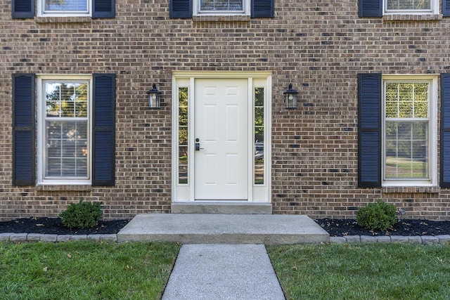 property entrance featuring brick siding