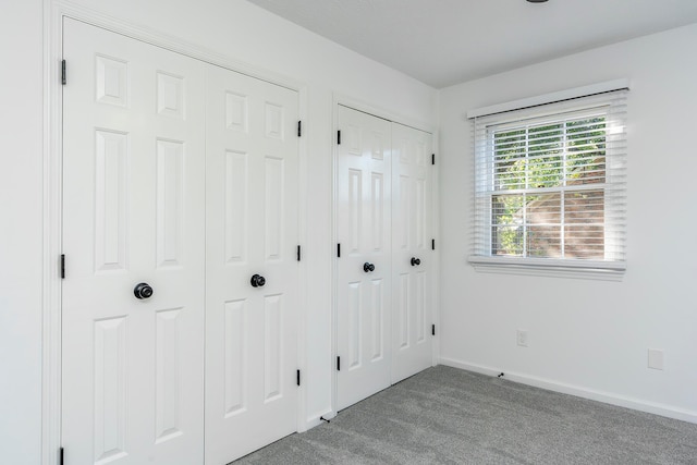 interior space featuring light colored carpet and two closets