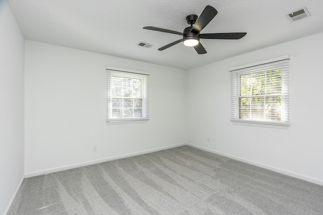 empty room featuring baseboards, a ceiling fan, carpet floors, and visible vents