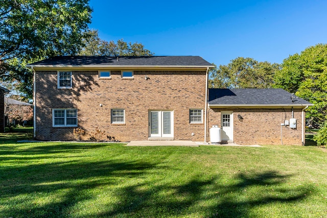 back of property with a lawn and a patio area