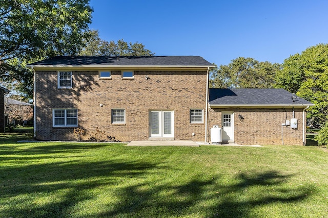 back of house with a yard, a patio, and brick siding