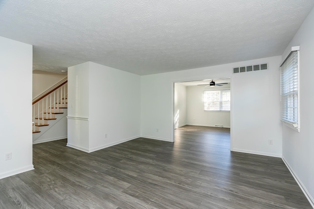 unfurnished room featuring ceiling fan, a textured ceiling, and dark hardwood / wood-style floors