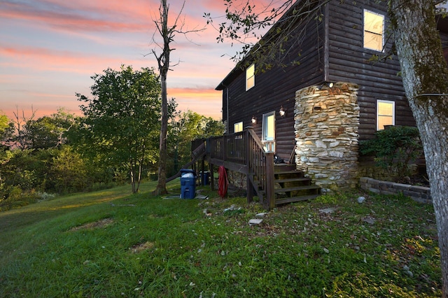 property exterior at dusk featuring a lawn