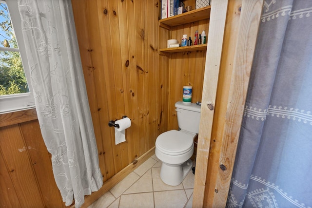 bathroom featuring wood walls, tile patterned flooring, and toilet