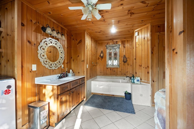 bathroom featuring wood walls, a bathtub, tile patterned floors, and vanity