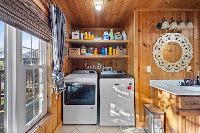 washroom featuring light tile patterned floors, wooden walls, washer and clothes dryer, and wood ceiling